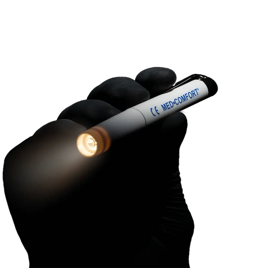 Diagnostikleuchte weiß Med-Comfort mit LED-Licht, gehalten von einer Hand in schwarzem Handschuh, ideal für medizinische Untersuchungen.