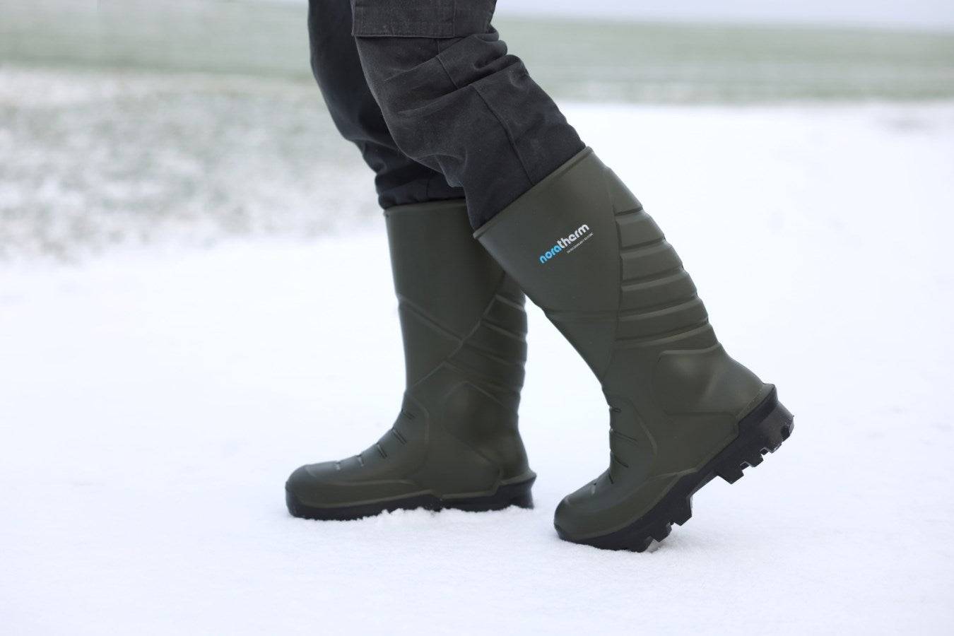Person trägt NORATHERM Thermo-Sicherheitsstiefel S5 im Schnee, kälteflexibel bis -50 °C, ideal für Arbeitseinsätze bei Frost