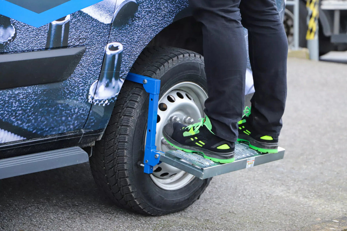 Reifen-Klapptritt einstellbar montiert an Kleintransporter, bietet sicheren Stand für Arbeiten an Fahrzeugdach oder Motorraum. Perfekt für 4x4 und Nutzfahrzeuge.